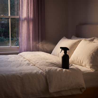 Drift pillow mist on a made bed in evening light