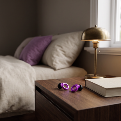 Silent Rest earplugs on a nightstand beside a book and a lamp